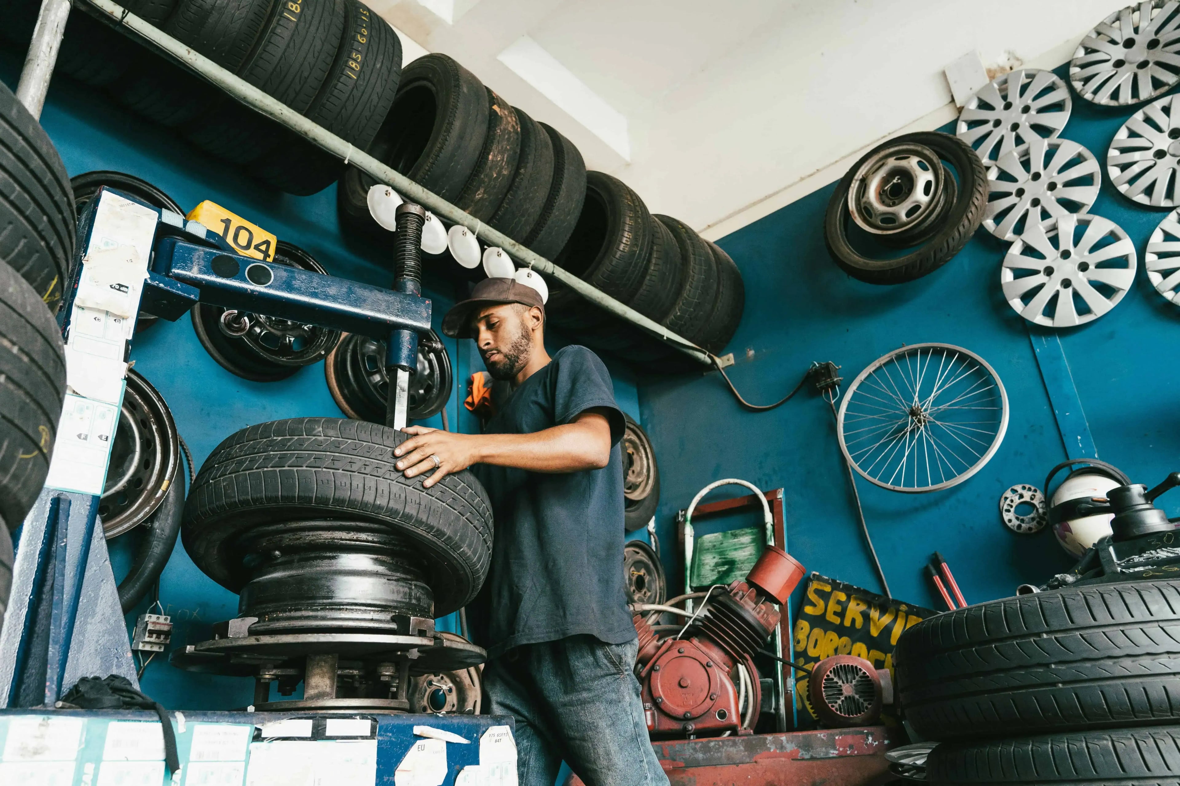 A man is working on a car wheel